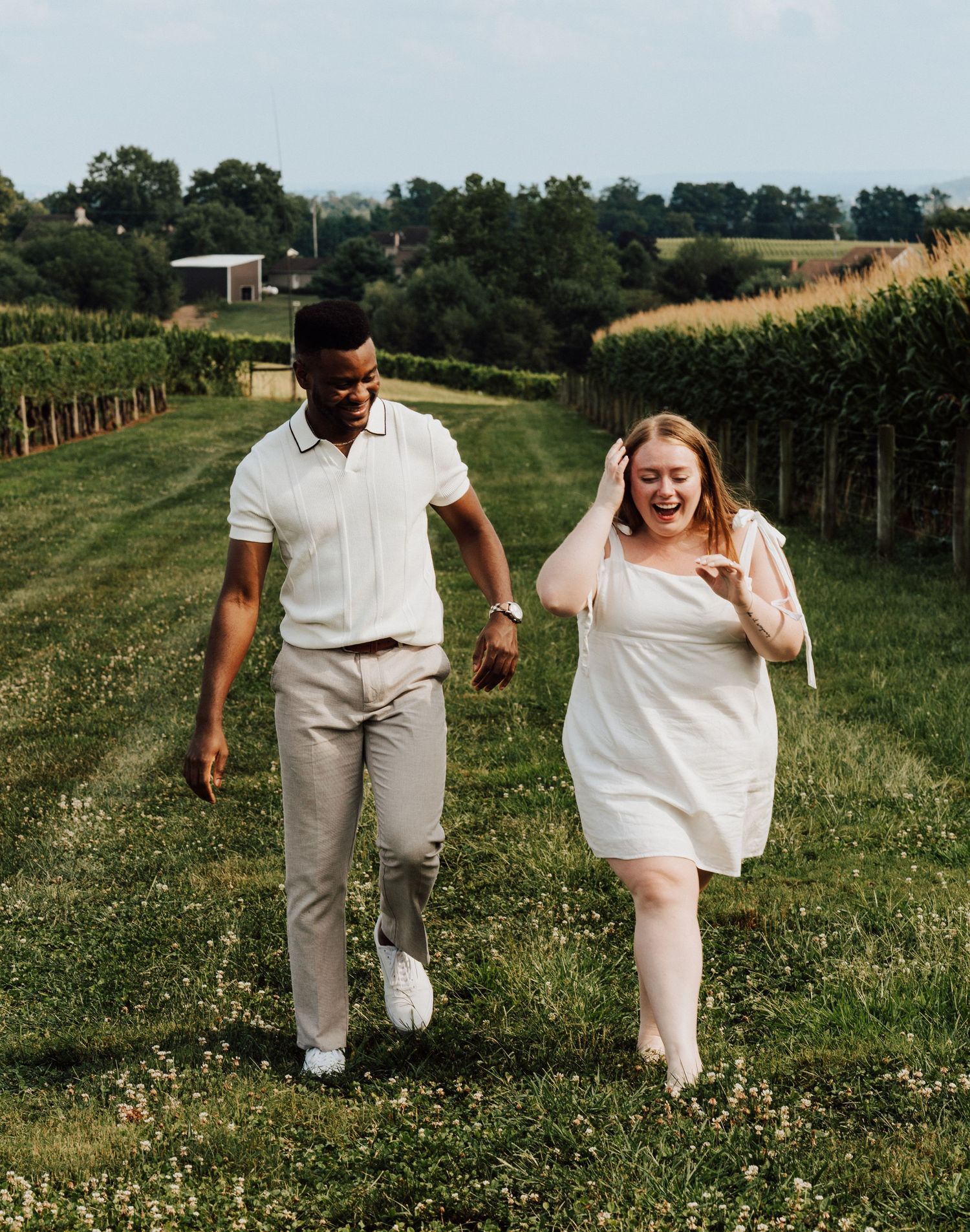 A couple running and laughing together in for Engagement Photoshoot at Waltz Vineyards Estate Winery in Manheim, PA