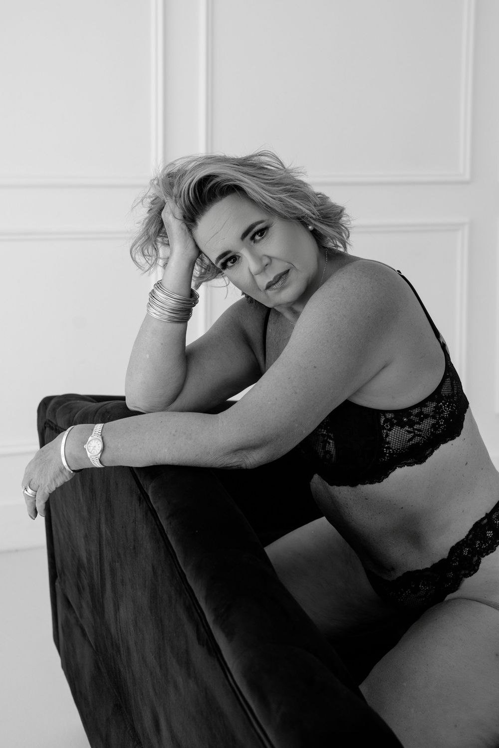 Intimate black and white boudoir portrait featuring dark lingerie and moody lighting.