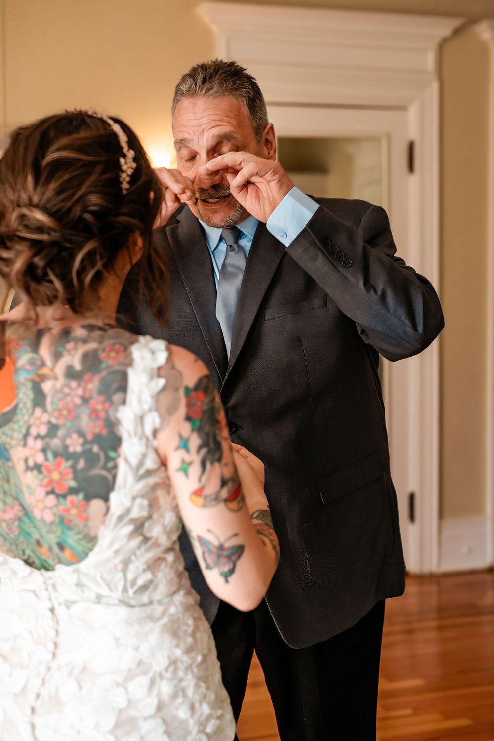 father of the bride wiping away tears as he moves towards his daughter in the grant Humphreys mansion bridal suite