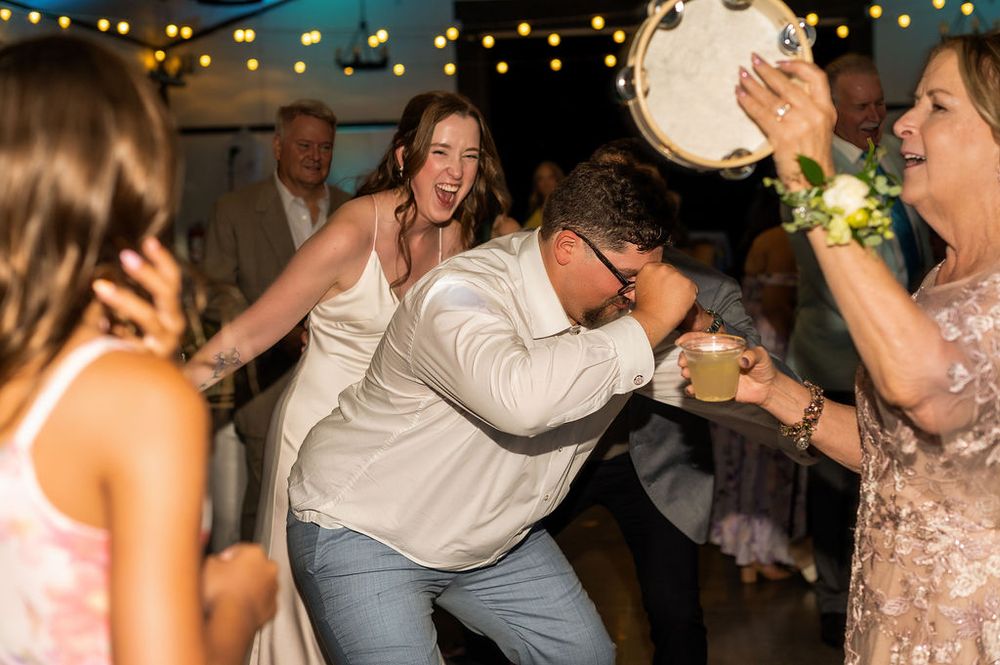 husband and wife wildly laughing at their wedding reception at Chatfield farms
