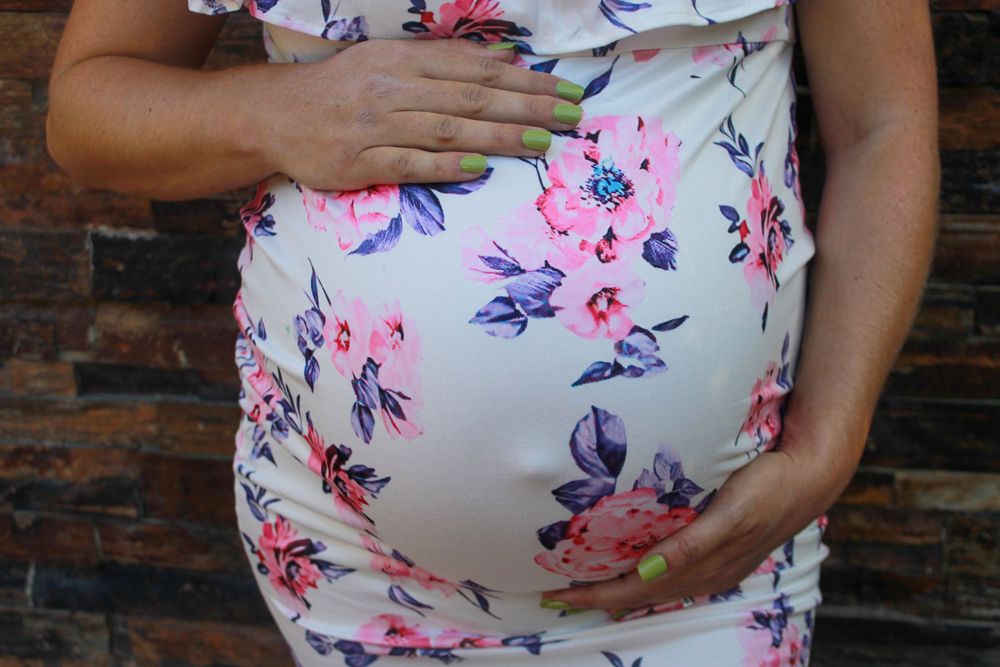 Close-up of maternity dress with delicate pink and purple flower print.