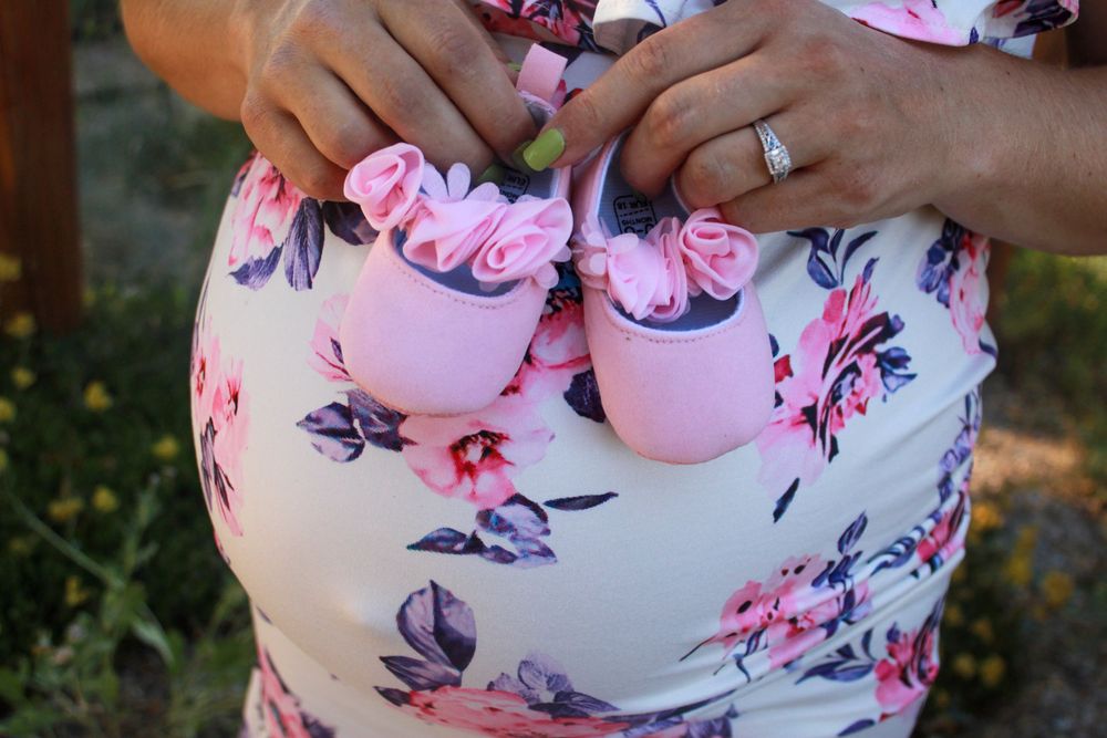 Collage of a pregnant belly showing baby bump progression in pink floral maternity dress.