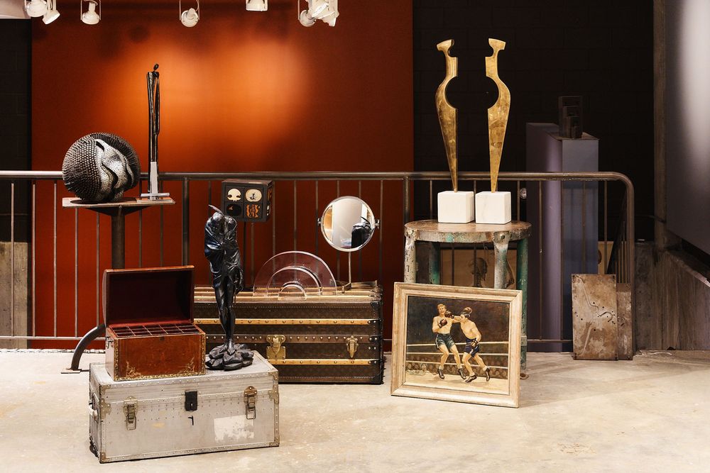 Vintage studio photography equipment and props displayed in a museum-like setting with warm lighting and wooden accents.