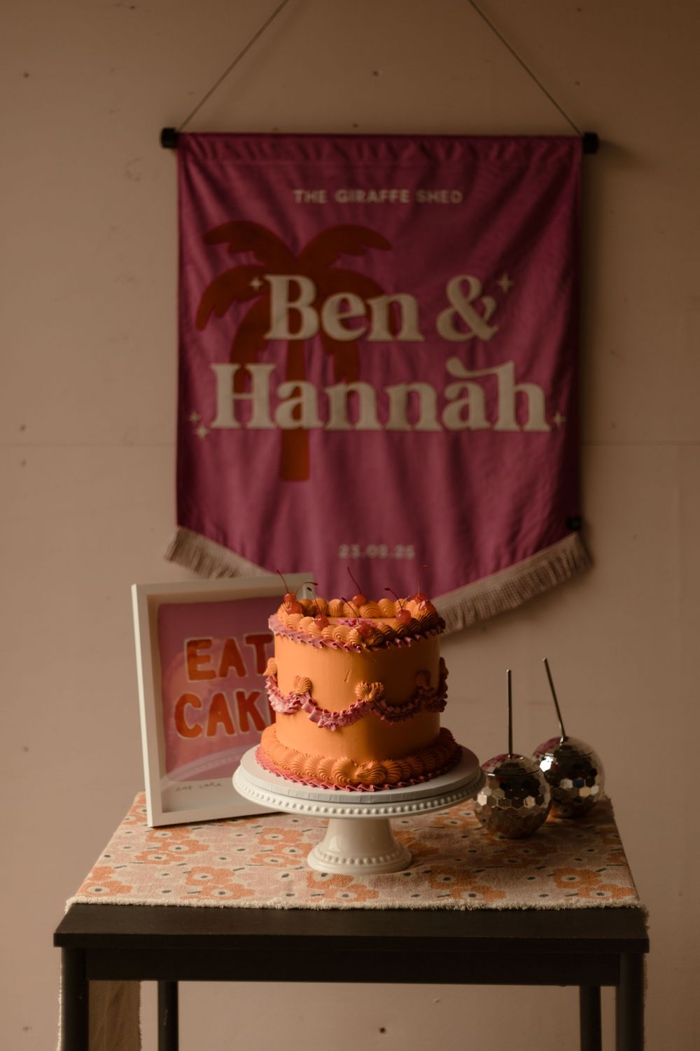 Five sequential pink and orange toned cake photographs against a beige wall with hanging banners create a dreamy composition.