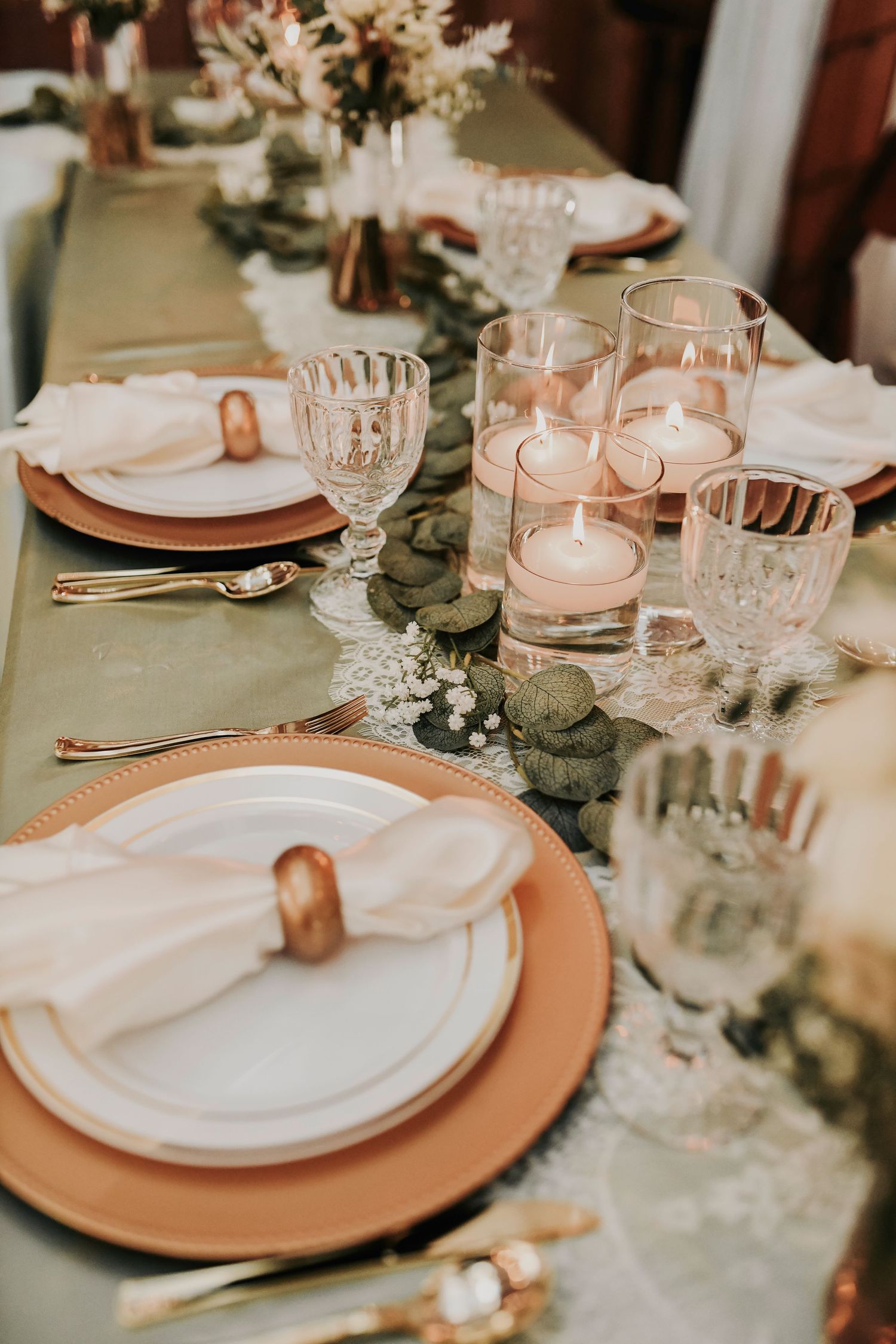 Elegant boho-inspired wedding décor with greenery runners and glowing candlelight by april pinto photography
