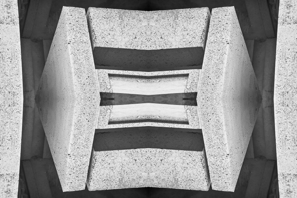Abstract black and white architectural photograph showing geometric shapes and symmetrical patterns in a modern structure.