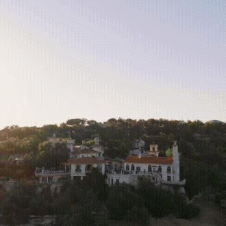 A scenic panoramic view of a Mediterranean coastal town with white buildings nestled along hills near the sea.