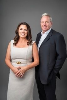 Professional gray studio portraits of a couple posing together in formal attire.
