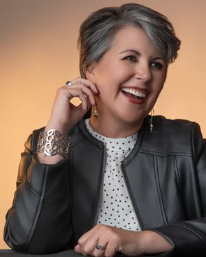 Professional headshot series showing different poses in a black leather jacket and polka dot blouse against a warm backdrop.
