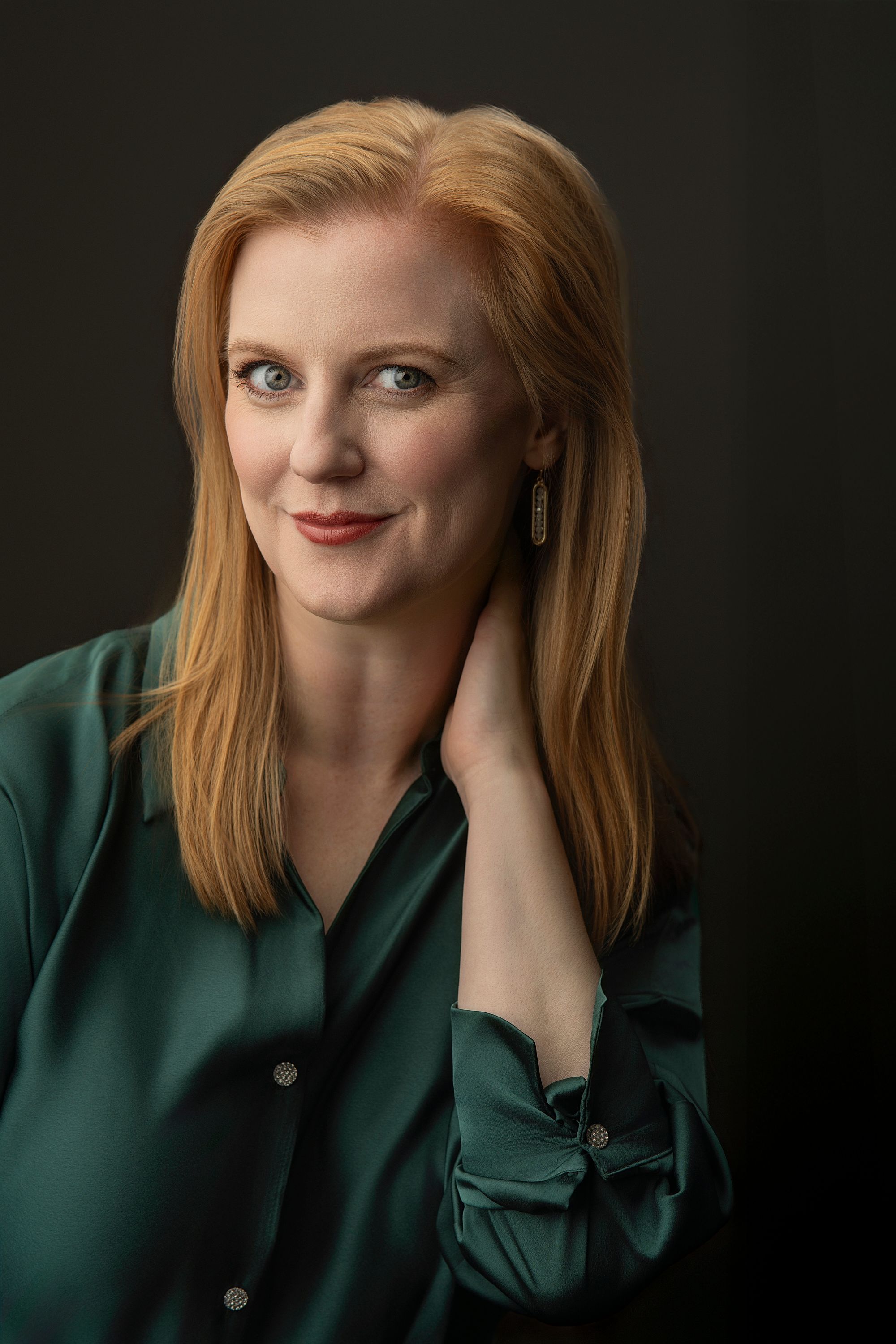 A series of four portrait photos showing someone in a green blazer with red lipstick and blonde hair against a dark background.