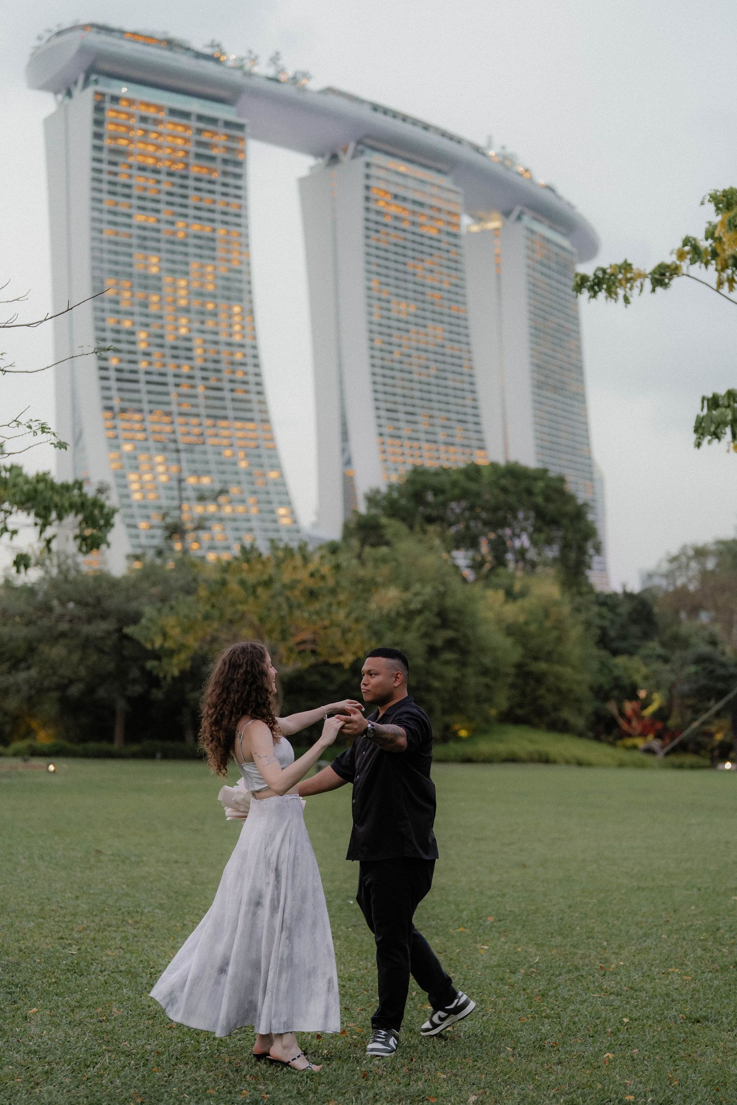 Playful dance moves with Marina Bay Sands hotel visible in the background of Singapore.