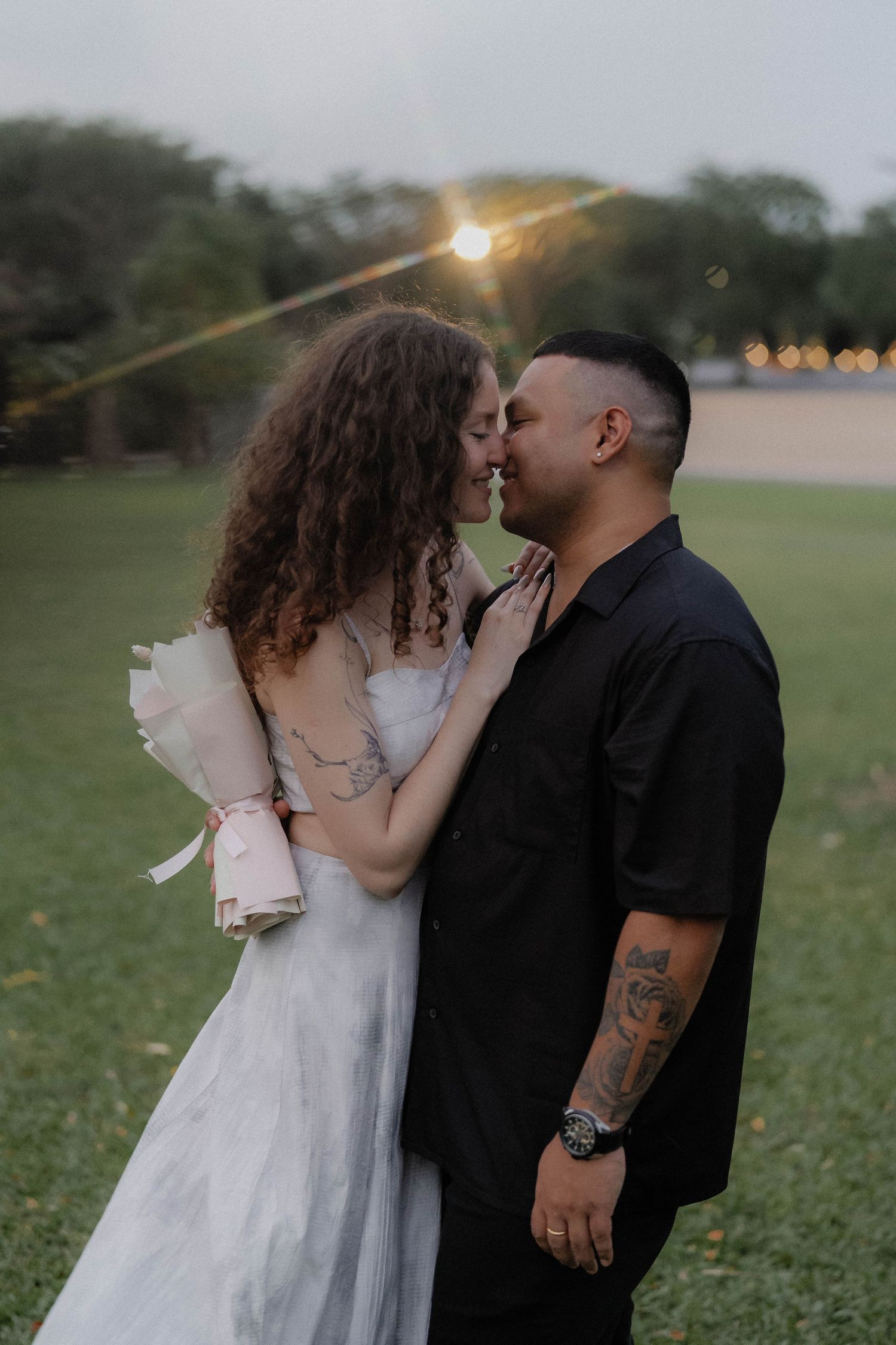 A romantic sunset moment captured between a couple in wedding attire in an outdoor setting.