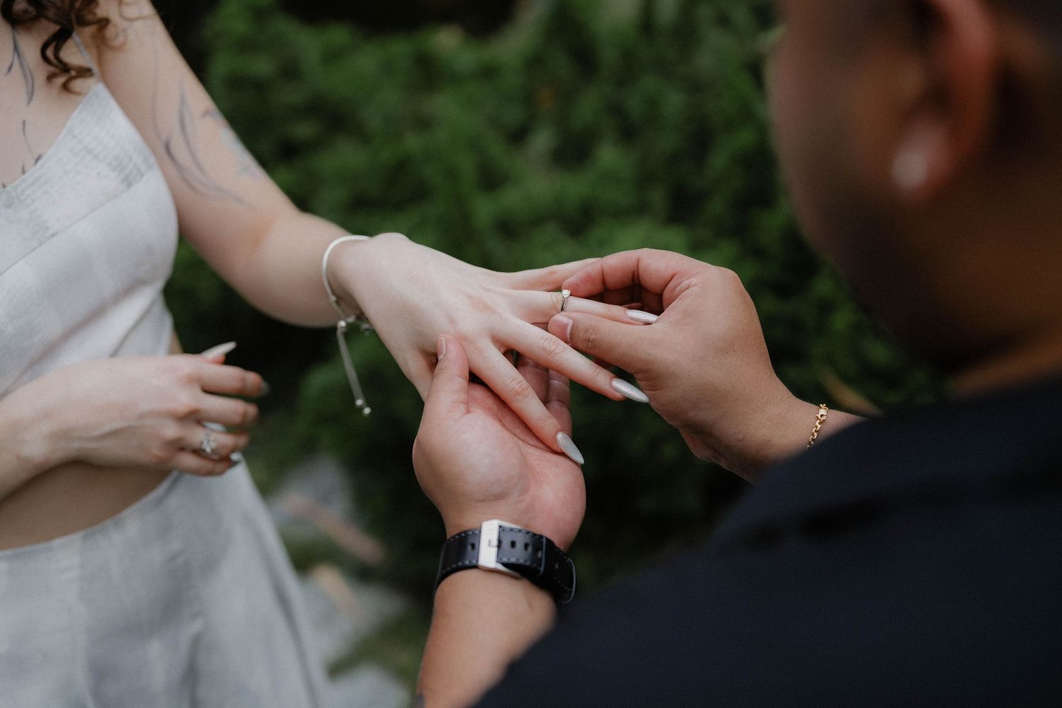 A close-up of a ring being placed on a hand during a proposal.