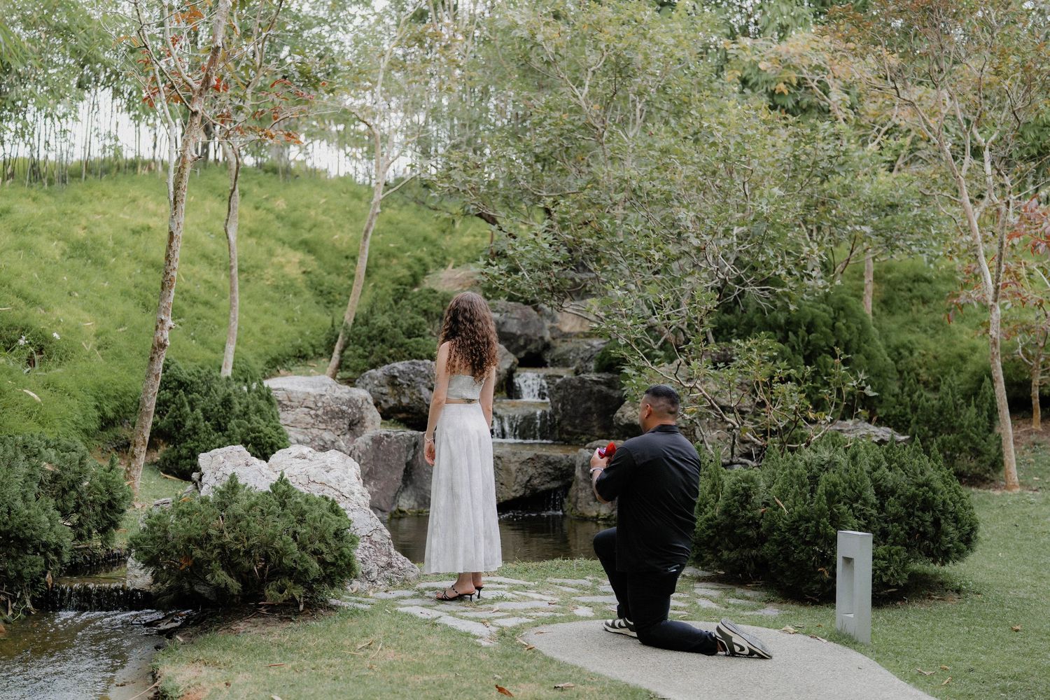 A couple having fun during their wedding photo session in a beautiful garden landscape.