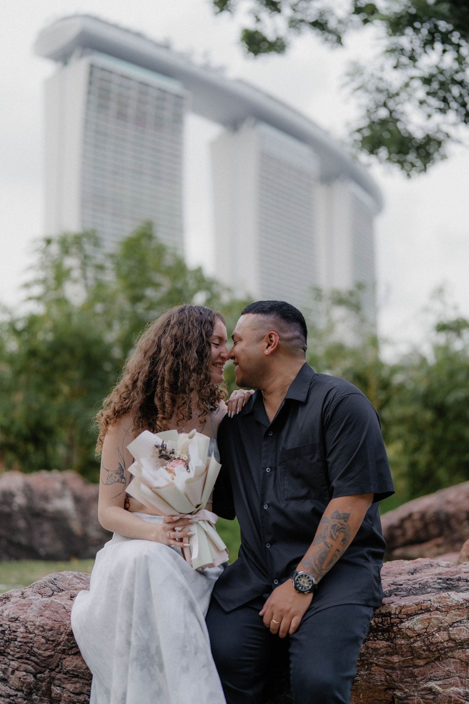A couple sharing an intimate moment with Marina Bay Sands towering in the background.