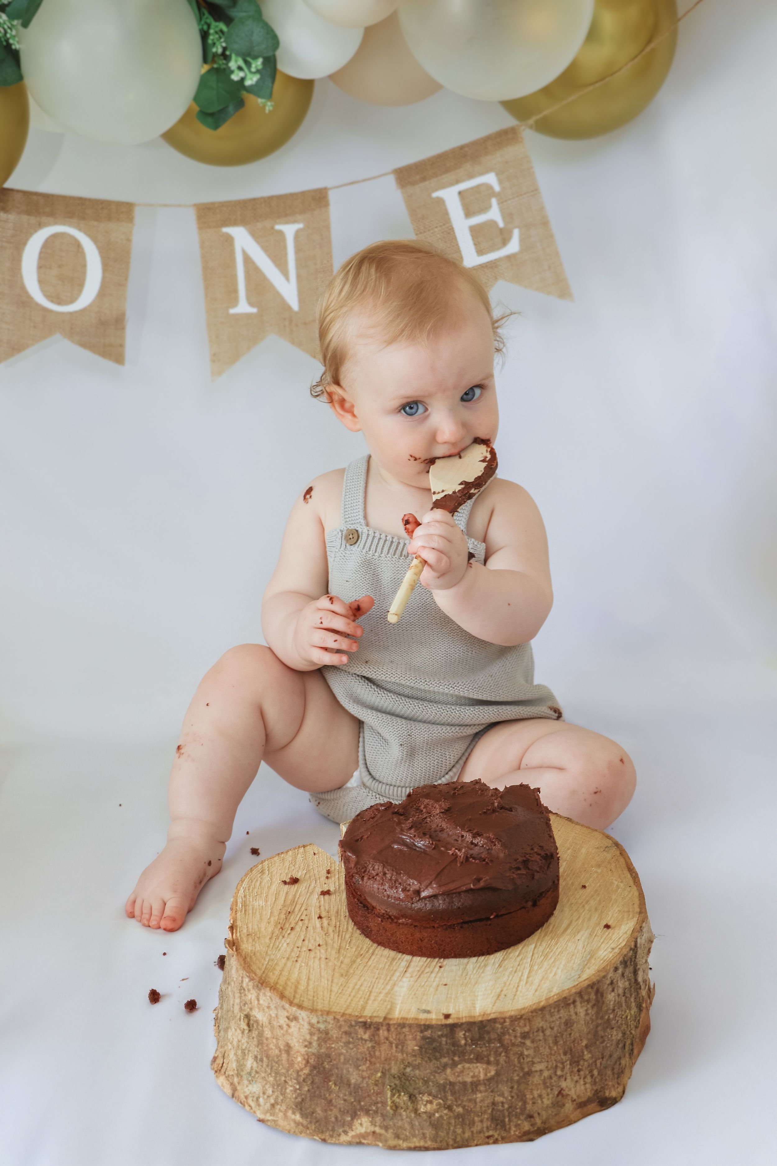 A cake smash photo sequence shows a first birthday celebration on a rustic wood slice with balloons in the background.