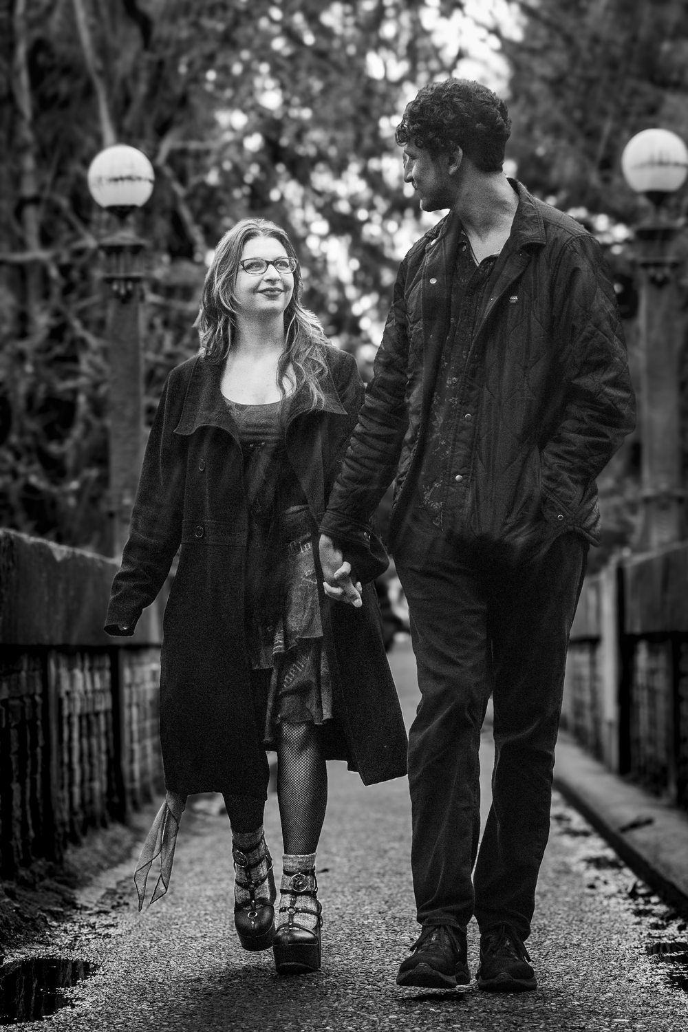 A romantic couple in dark jackets walking together on a tree-lined path, split into multiple black and white frames.