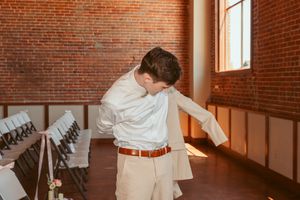 Natural light streams through windows in rustic brick venue during celebration.