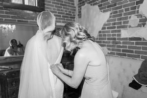 Wedding celebration scene with people dancing in elegant venue with brick walls.