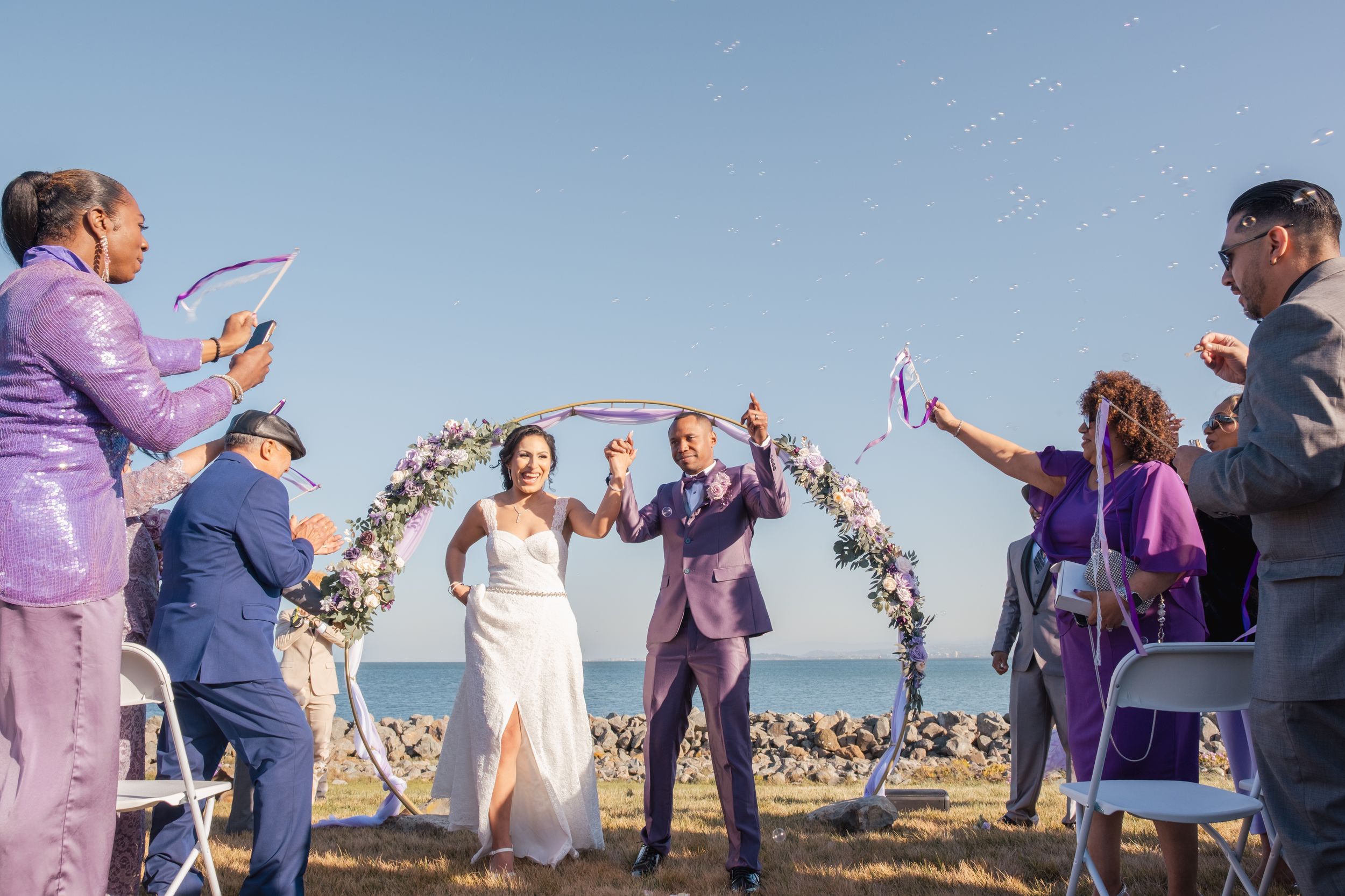 Couple walking down the aisle during a lilac themed wedding.