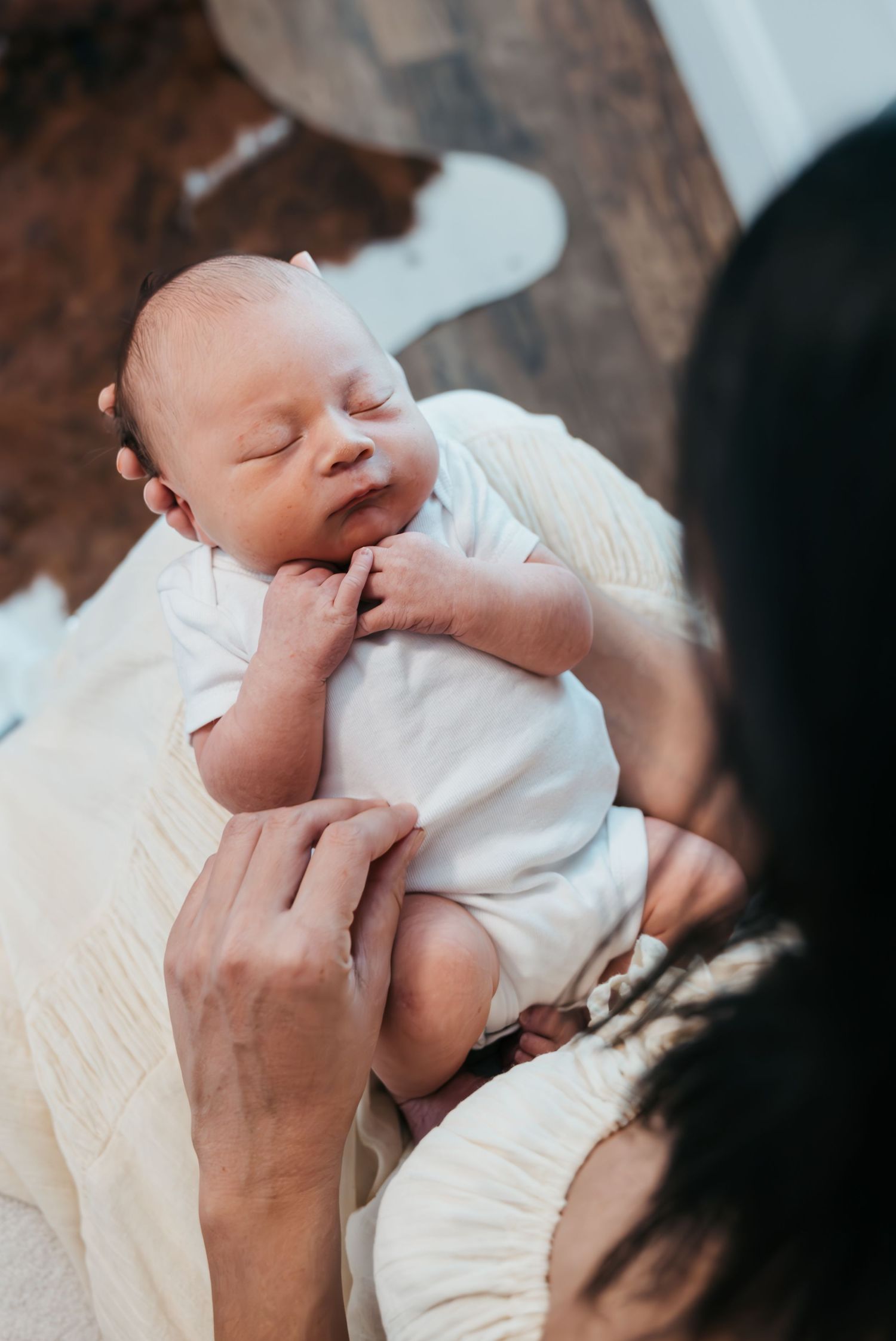 New family cuddling their newborn during in-home lifestyle session in Stuart Florida, newborn photographer in home session, treasure coast