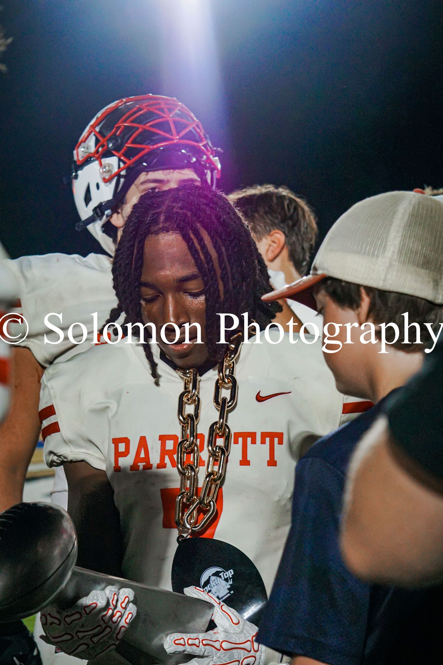 Parrott football player proudly wears MVP chain award after victory, captured by Solomon Photography.