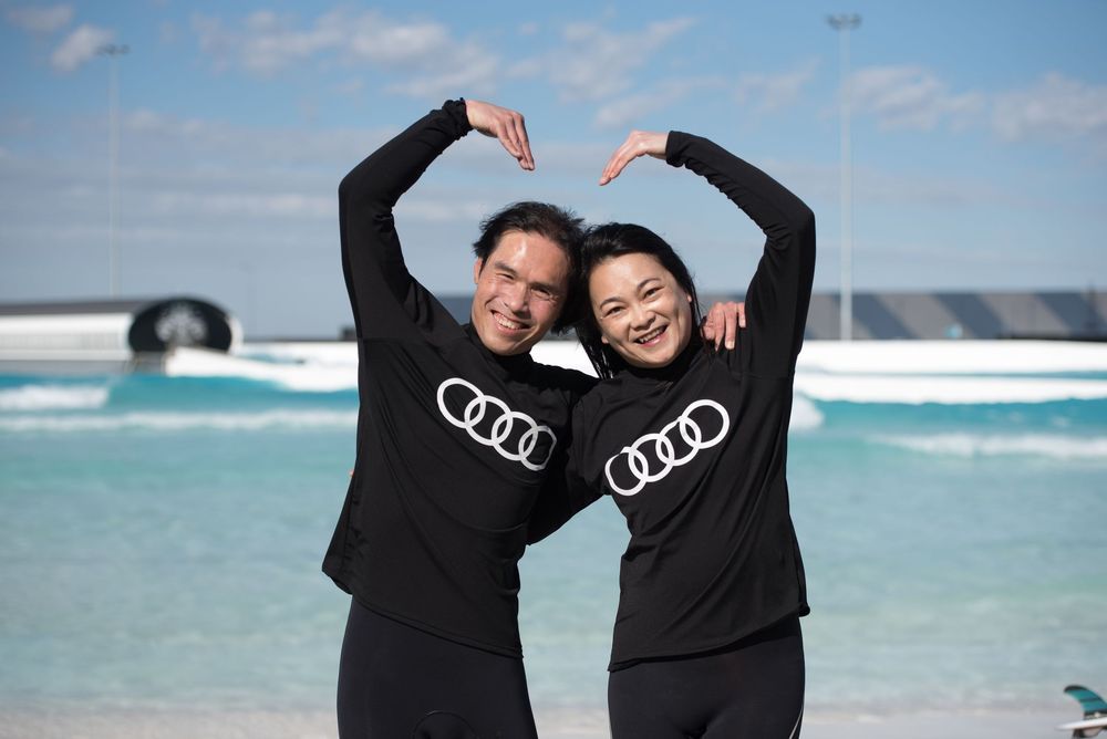 Two people at a audi and urbnsurf surf event