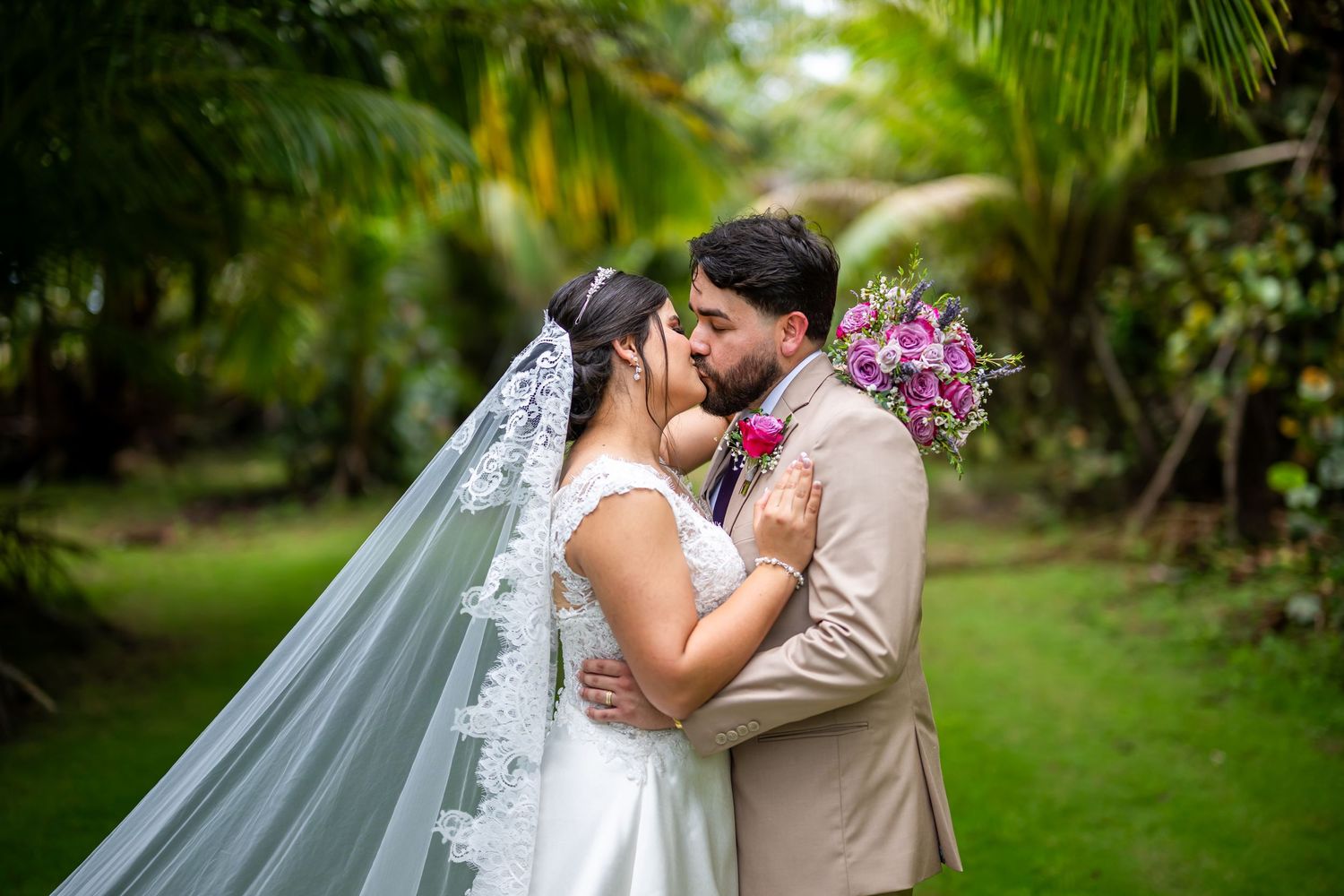 Elegant outdoor garden wedding ceremony features couple sharing an intimate moment under lush green foliage by Daniel Pagan Photograph