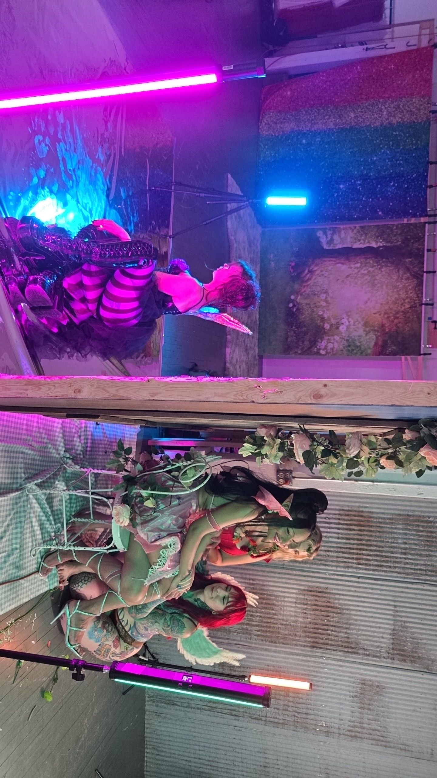Colorful neon lights illuminate a fantasy-themed set design with decorative branches and enchanted forest elements.
