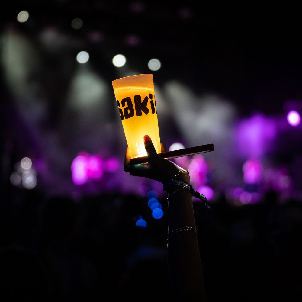 Concert stage lighting effects create a dramatic atmosphere with glowing purple and blue spotlights in darkness.