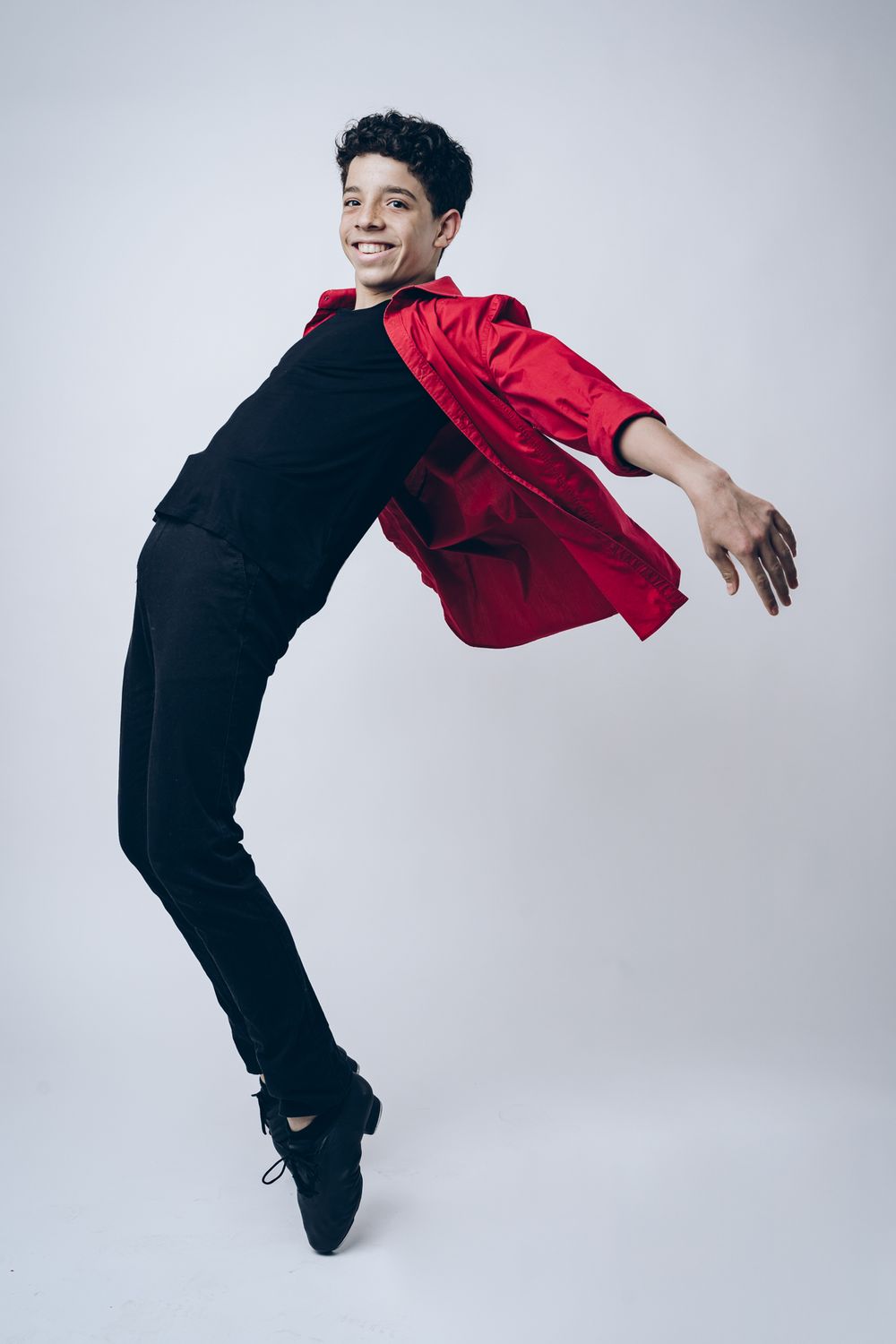 A sequence of photos showing energetic dance poses in red and black clothing against a light gray background.