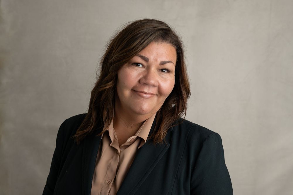 Professional portrait series showing multiple poses of a person in a black blazer against a gray backdrop.