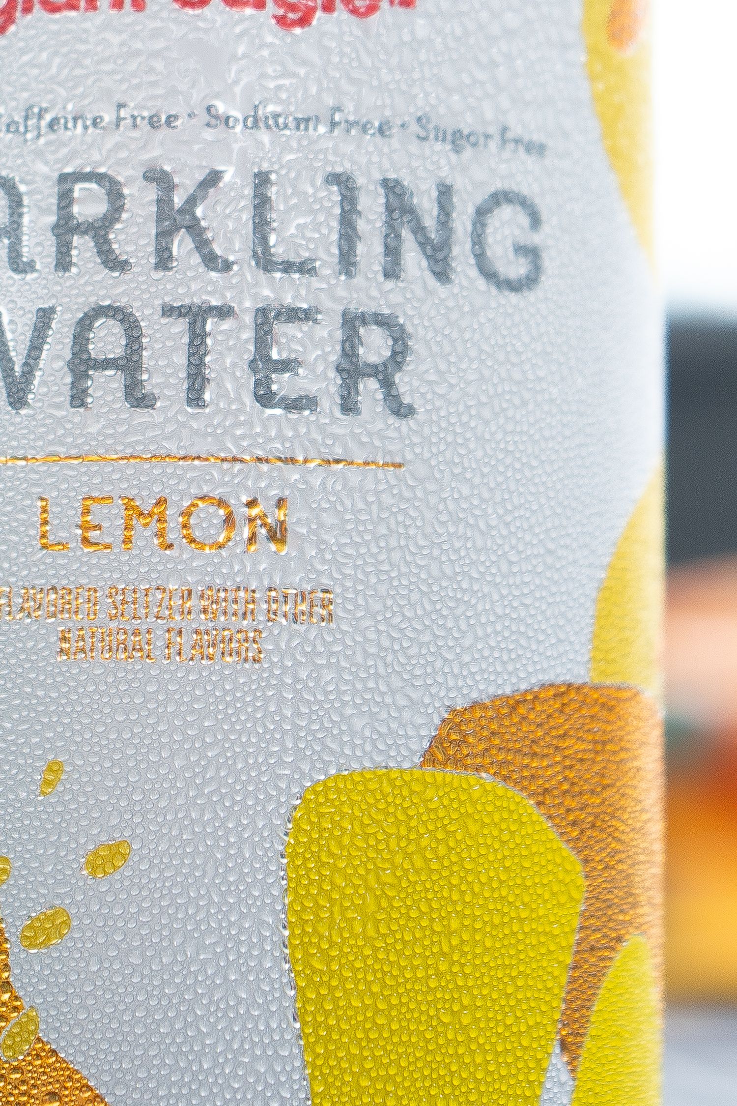 Detailed macro shot of condensation drops on a lemon-flavored sparkling water can.