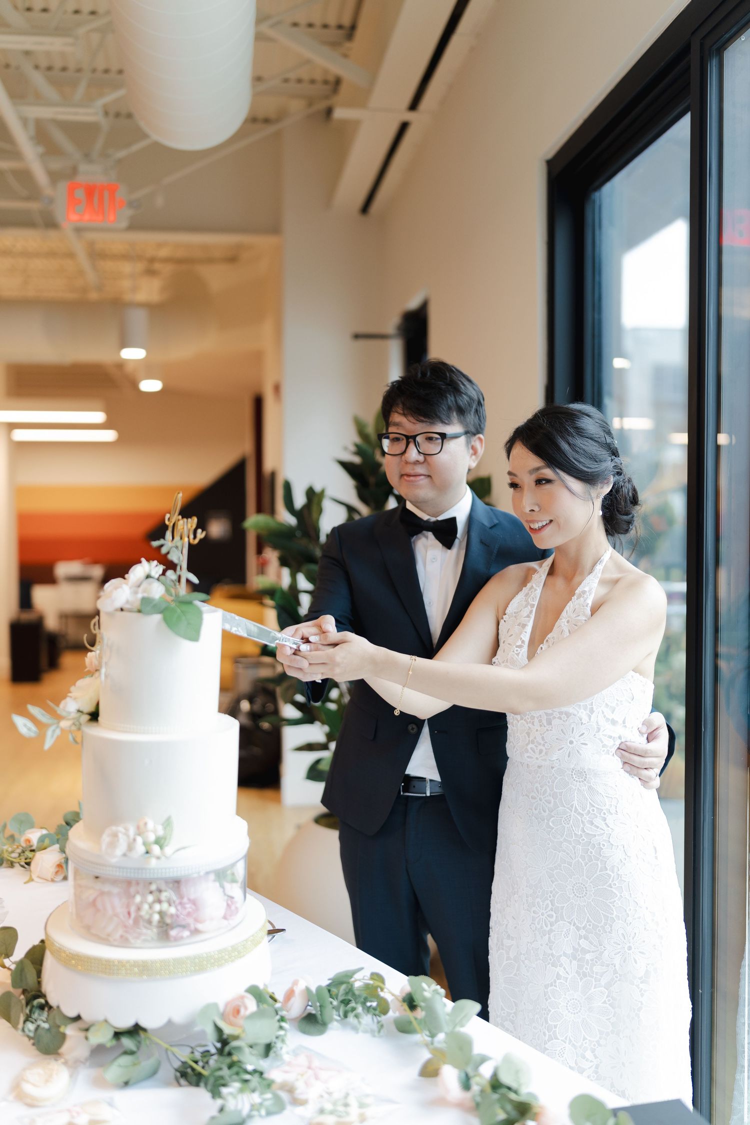 bride and groom cutting a 3 tier white wedding cake in an intimate wedding in Bloomington