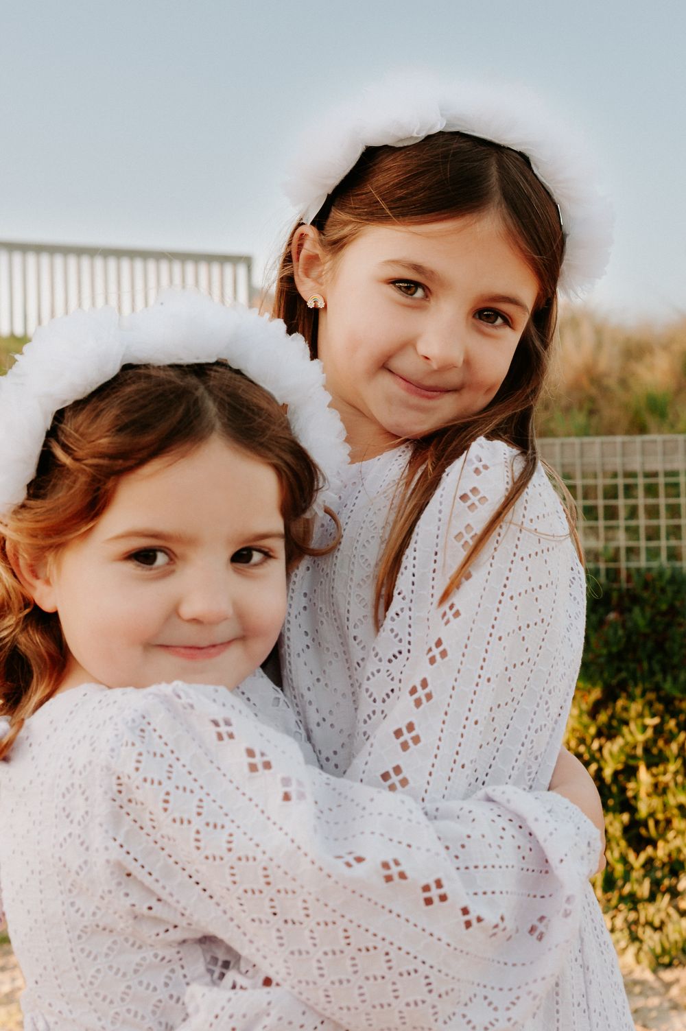 Two children wearing white dresses pose together outdoors on the beach.
Altona Family Photographer Melbourne