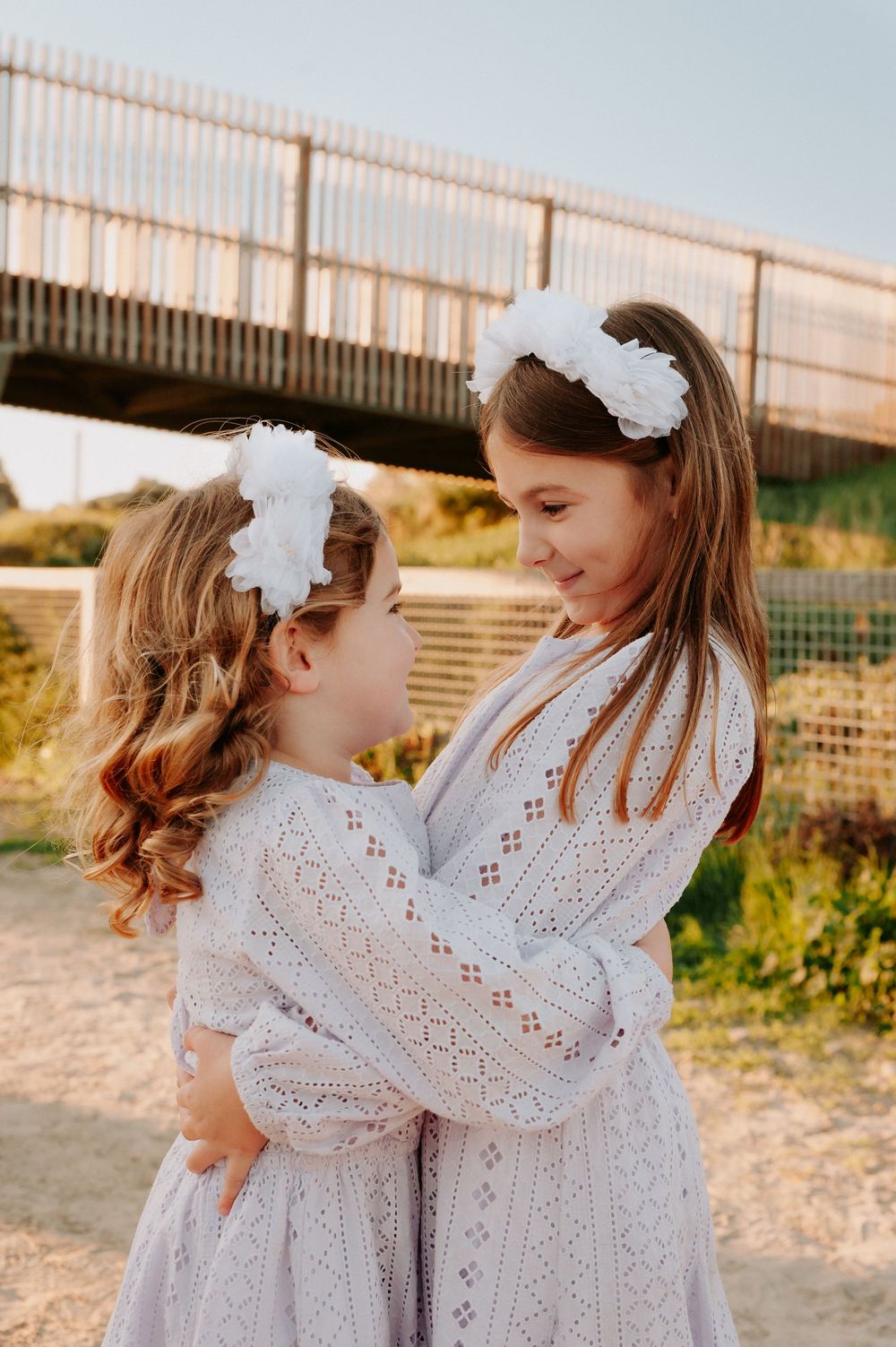 Two children in matching white dresses and floral headbands share a sweet moment during golden hour.
Altona Family Photographer Melbourne
