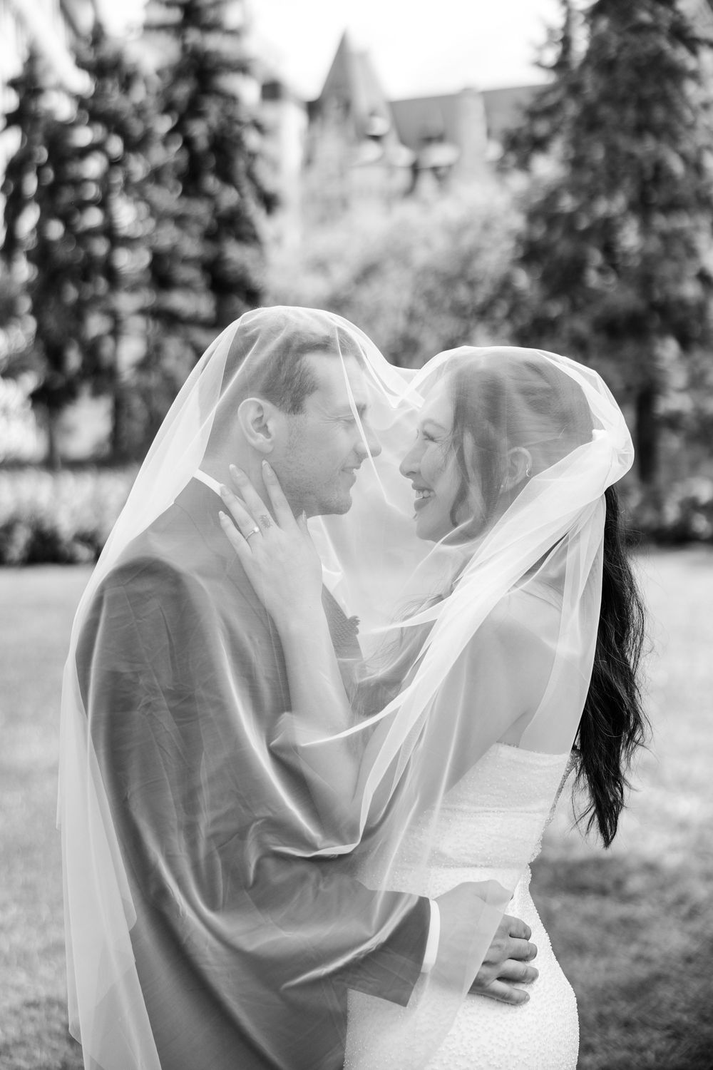 Black and white romantic wedding portrait sequence showing couple sharing intimate moments under flowing bridal veil.