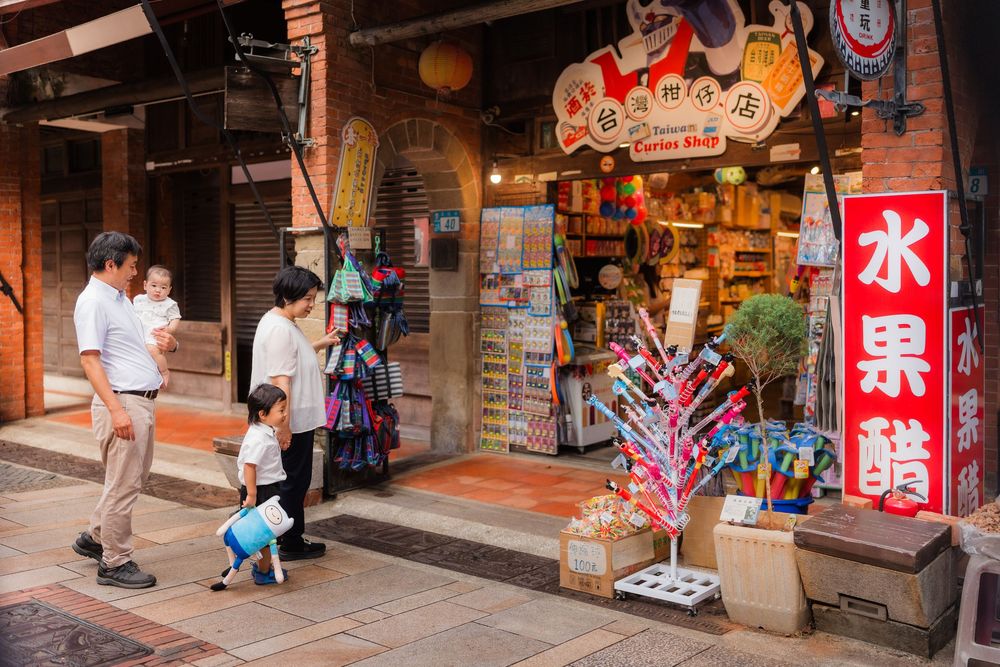 Panoramic view of a traditional Japanese shopping street with red lanterns and signs hanging from storefronts.