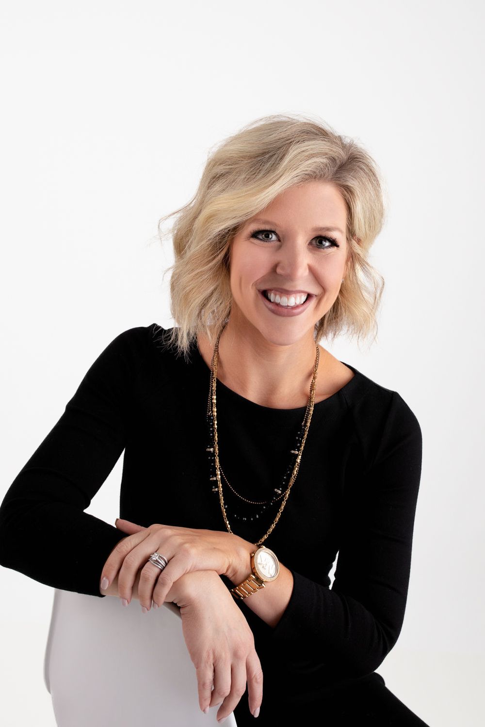 Professional headshots of someone in a black top against white background showing different poses and expressions.