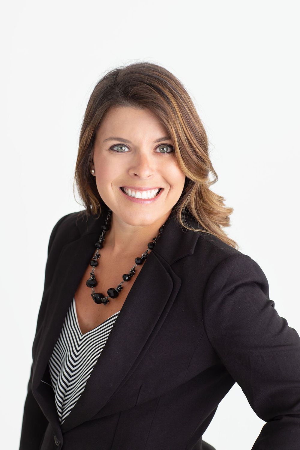 Professional business portrait series showing different poses in a black blazer against white background.