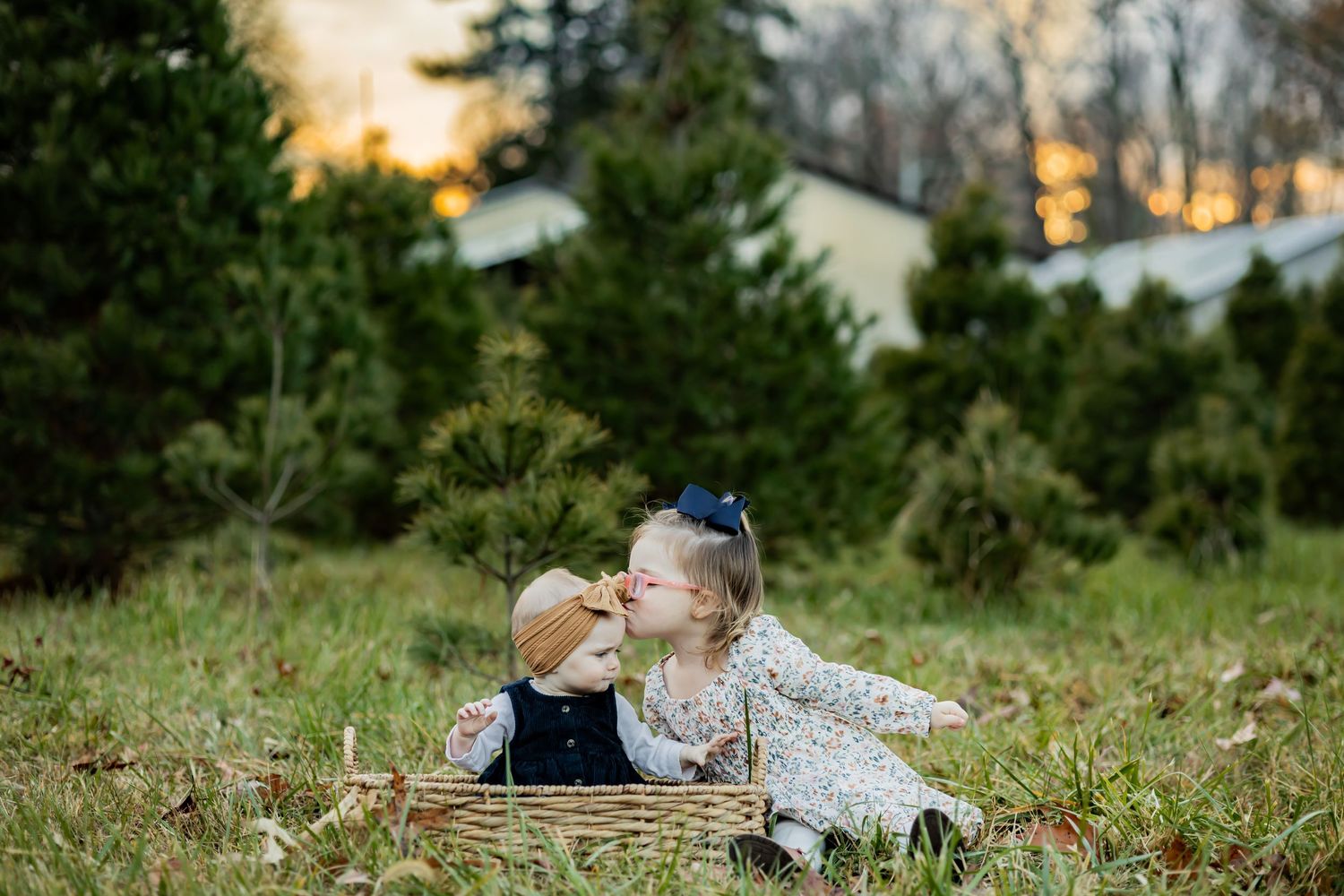 A couple shares an intimate moment on a bench against a festive holiday backdrop with snow-covered pine garland and decorations. RVA photo