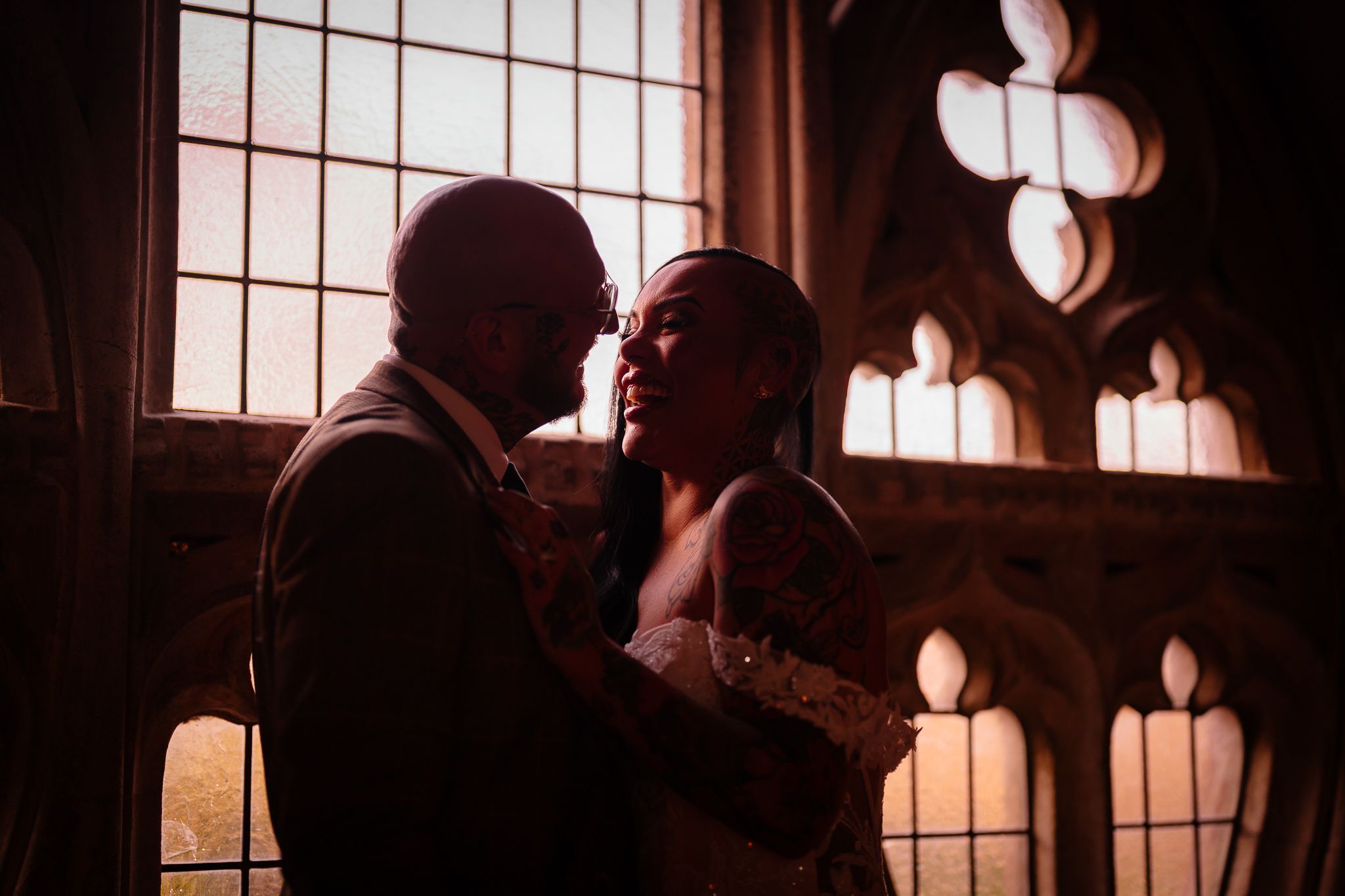 Dramatic silhouettes against ornate church windows creating moody atmosphere. Ellingham Hall