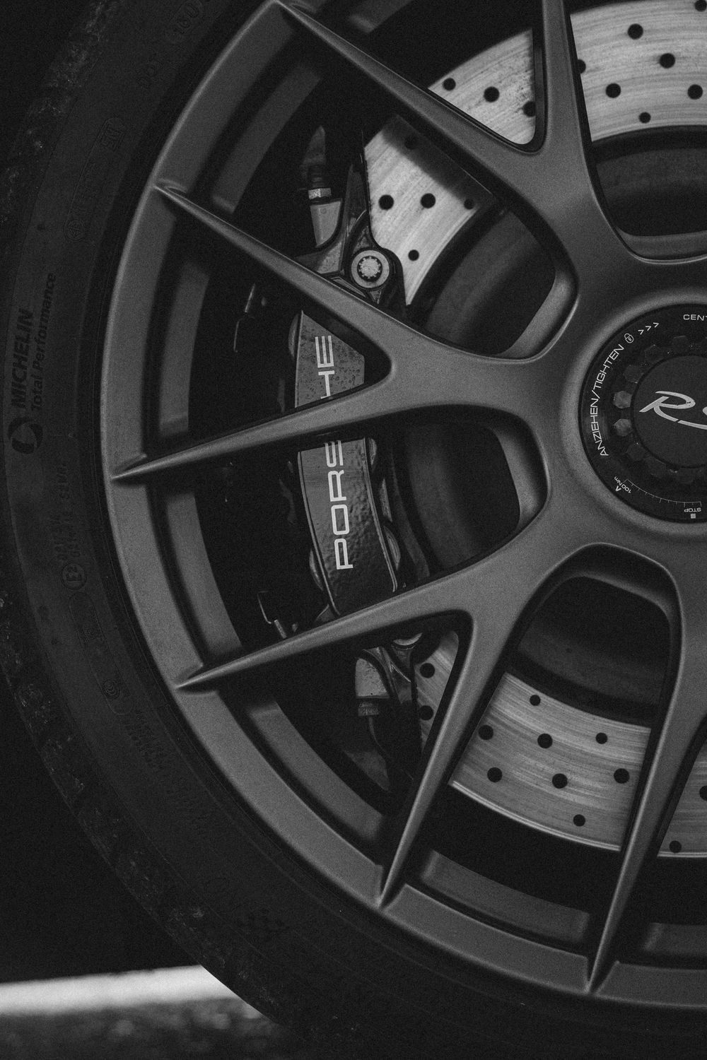 Detailed shot of dark performance brake rotors and wheels with intricate spoke design.