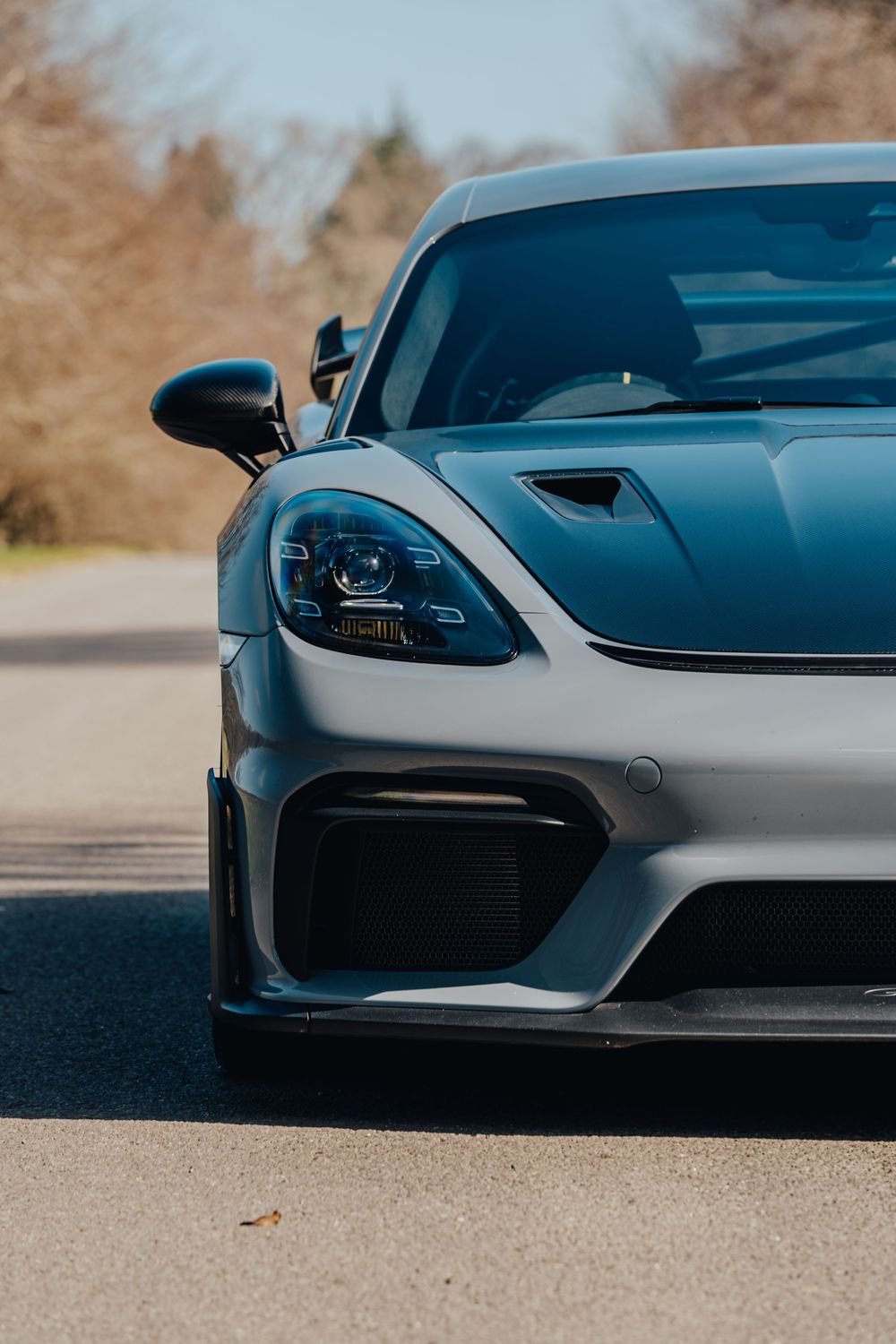 Close-up shots of a sleek silver sports car's front end design elements and headlights.