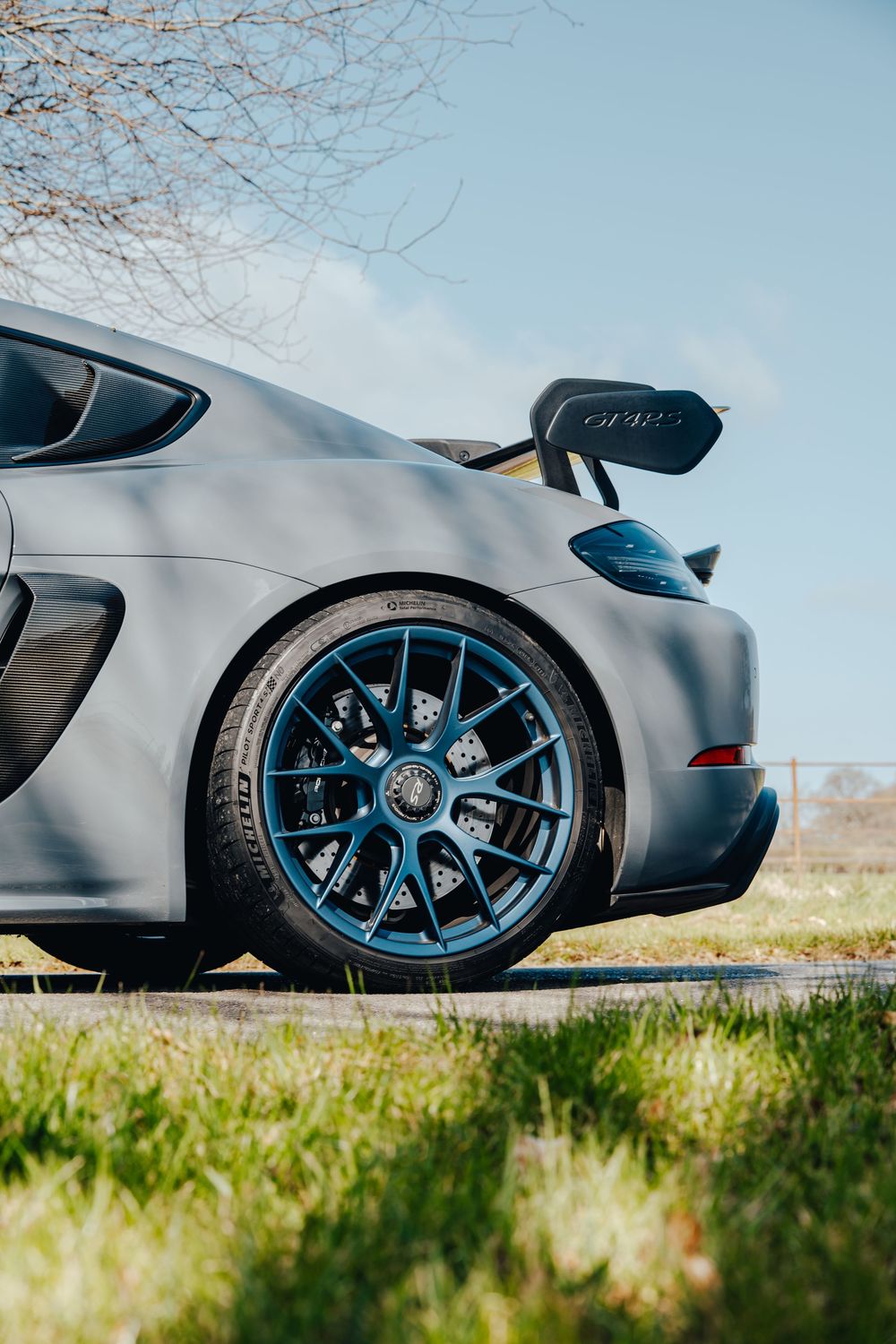 Close-up detail shot of Porsche GT4 RS wheel and side profile against natural background.