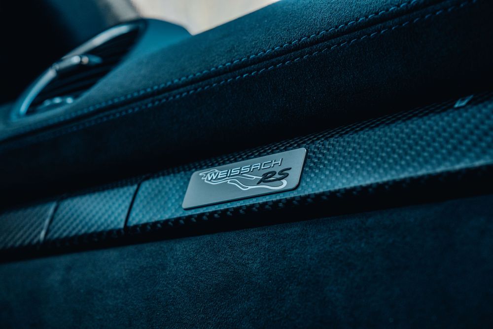 Detail shot of a Porsche GT4 RS interior badge on dark upholstery.