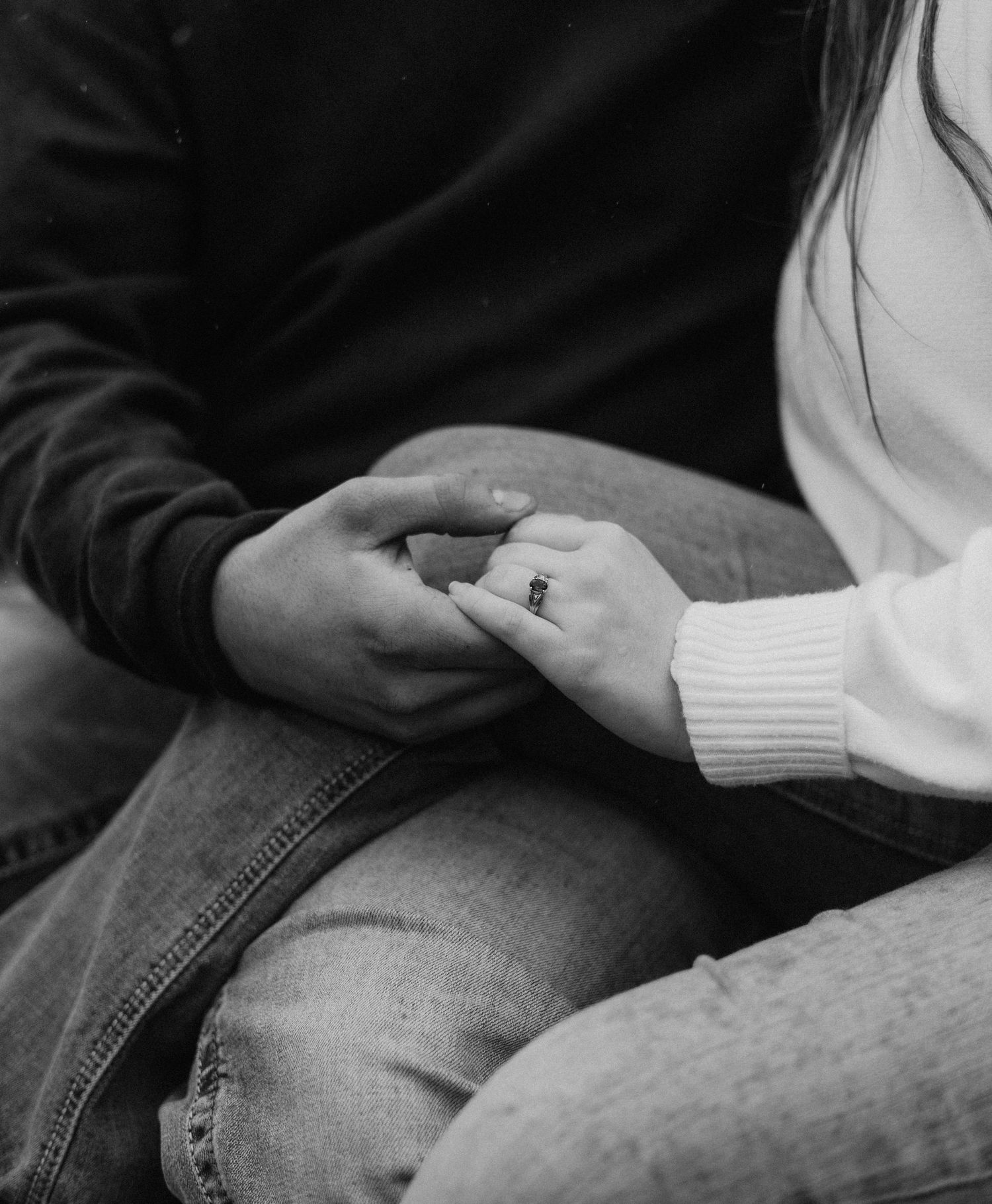 A sequence of black and white photos showing hands holding and exchanging a ring in a marriage proposal.