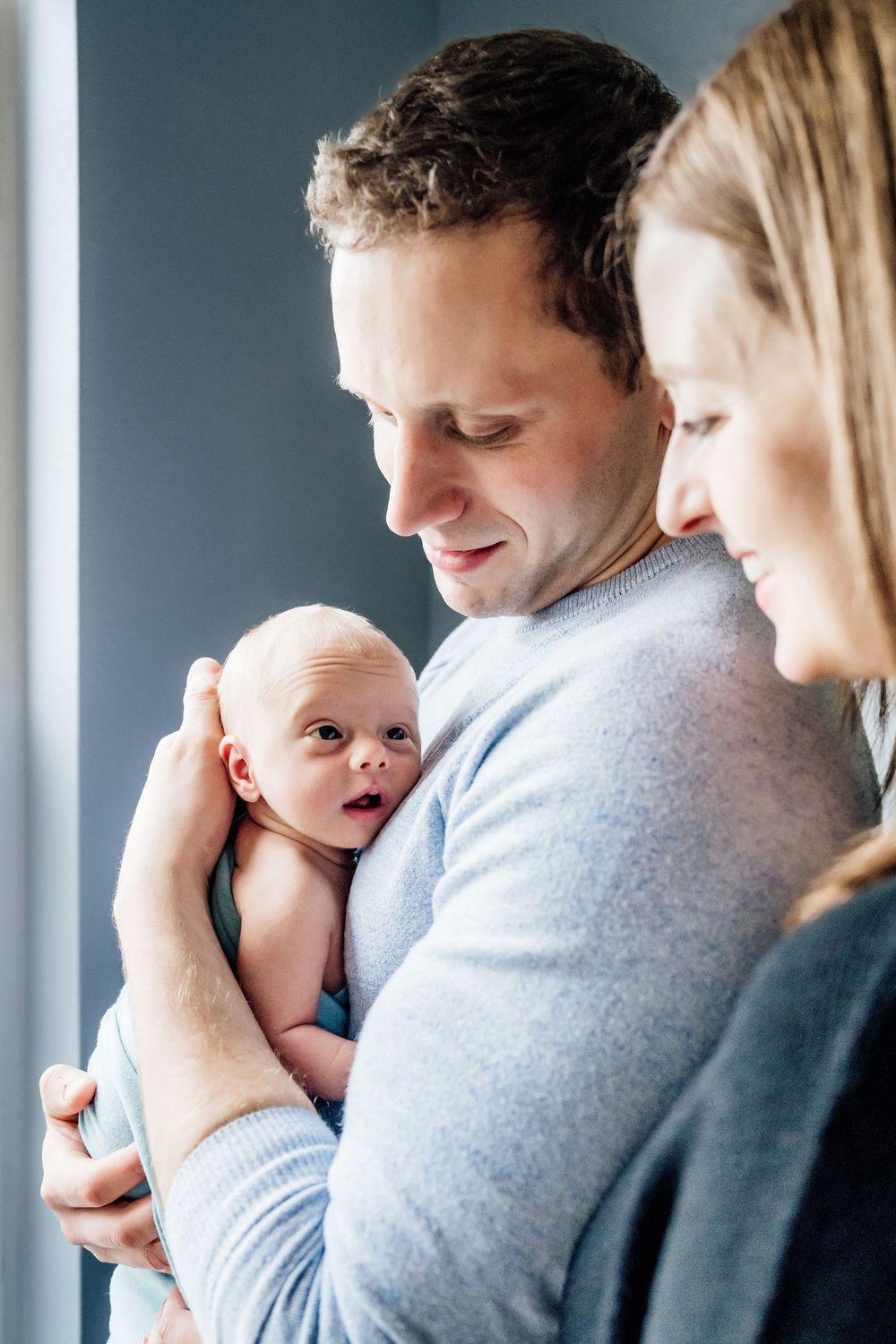 Intimate family moment captured in home setting with soft natural lighting.