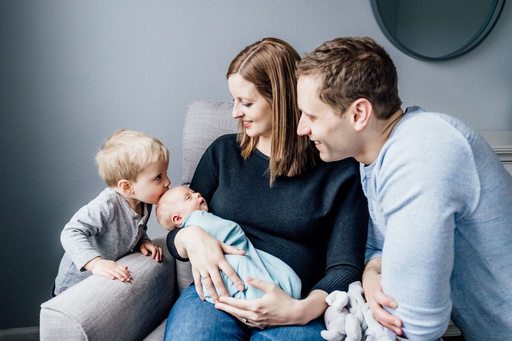 Family portrait session in modern home with blue-grey walls.