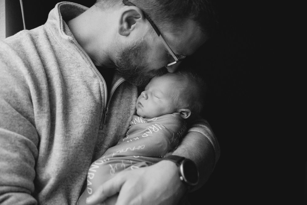 Intimate black and white portrait showing tender parental moment.